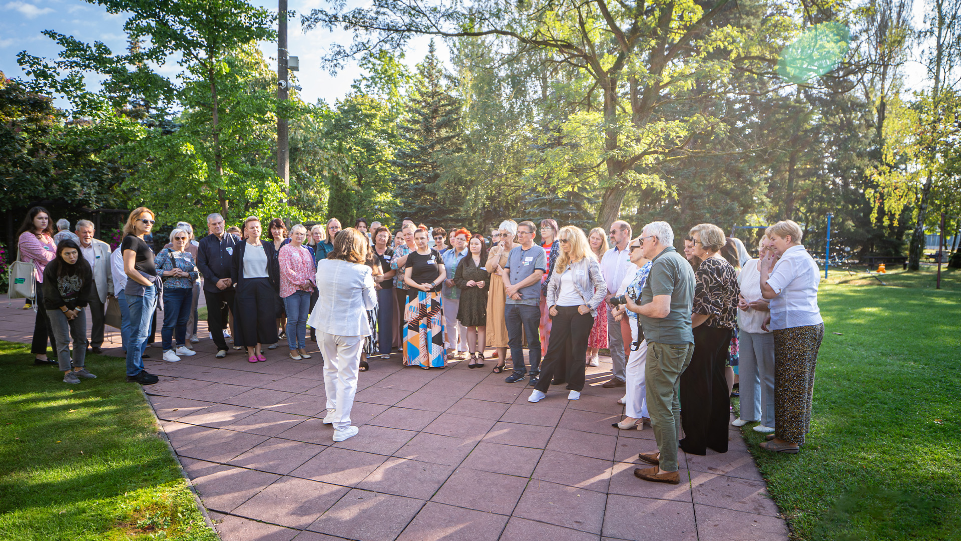 Duża grupa uczestników programu na zewnątrz w parku – społeczność z całej Polski