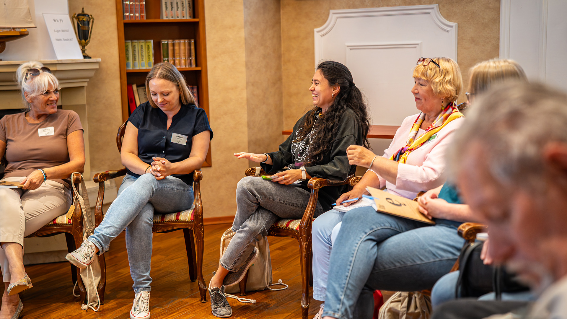 Osoby w różnym wieku siedzą w kręgu i rozmawiają – konsultacja